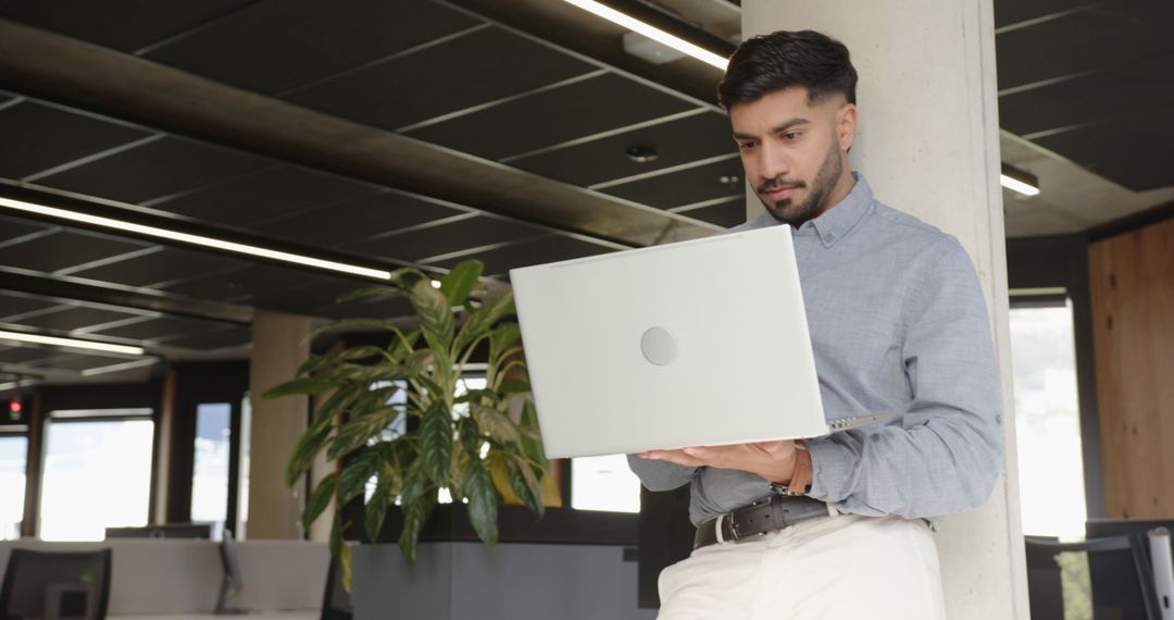 Young Professional Using Laptop in Contemporary Open Office