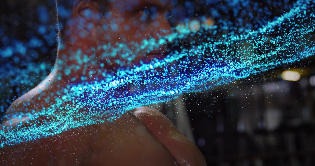 Glowing Cyan Particle Stream Veiling Shirtless Male Torso in Low Light Studio