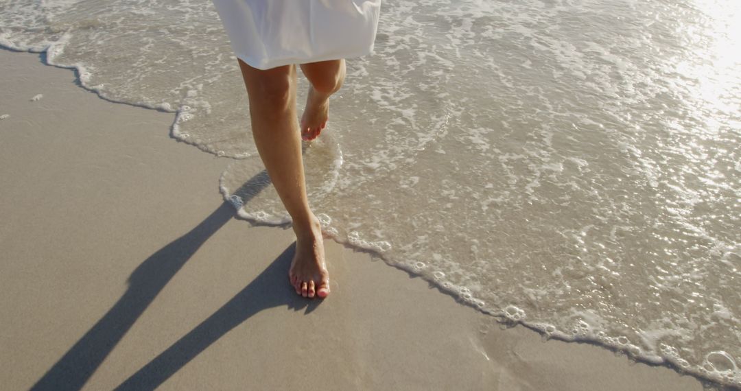 Close-Up of Barefoot Woman Walking on Beach Shore at Sunset - Free Images, Stock Photos and Pictures on Pikwizard.com