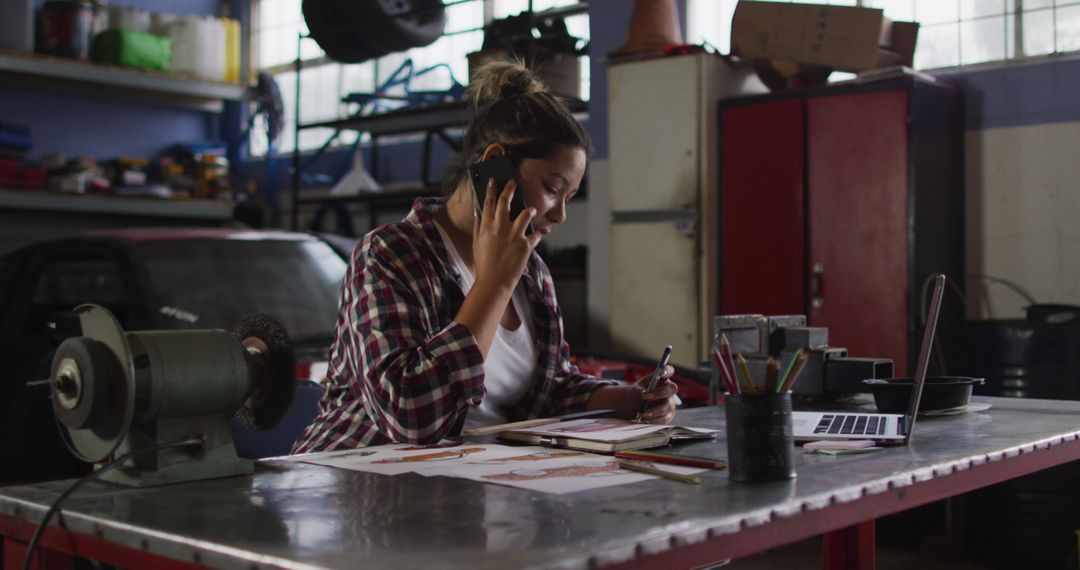 Female Mechanic Talking on Phone While Working in Auto Repair Shop - Free Images, Stock Photos and Pictures on Pikwizard.com