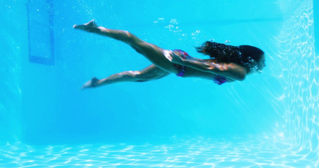 Woman Swimming Underwater in Bright Blue Pool - Free Images, Stock Photos and Pictures on Pikwizard.com