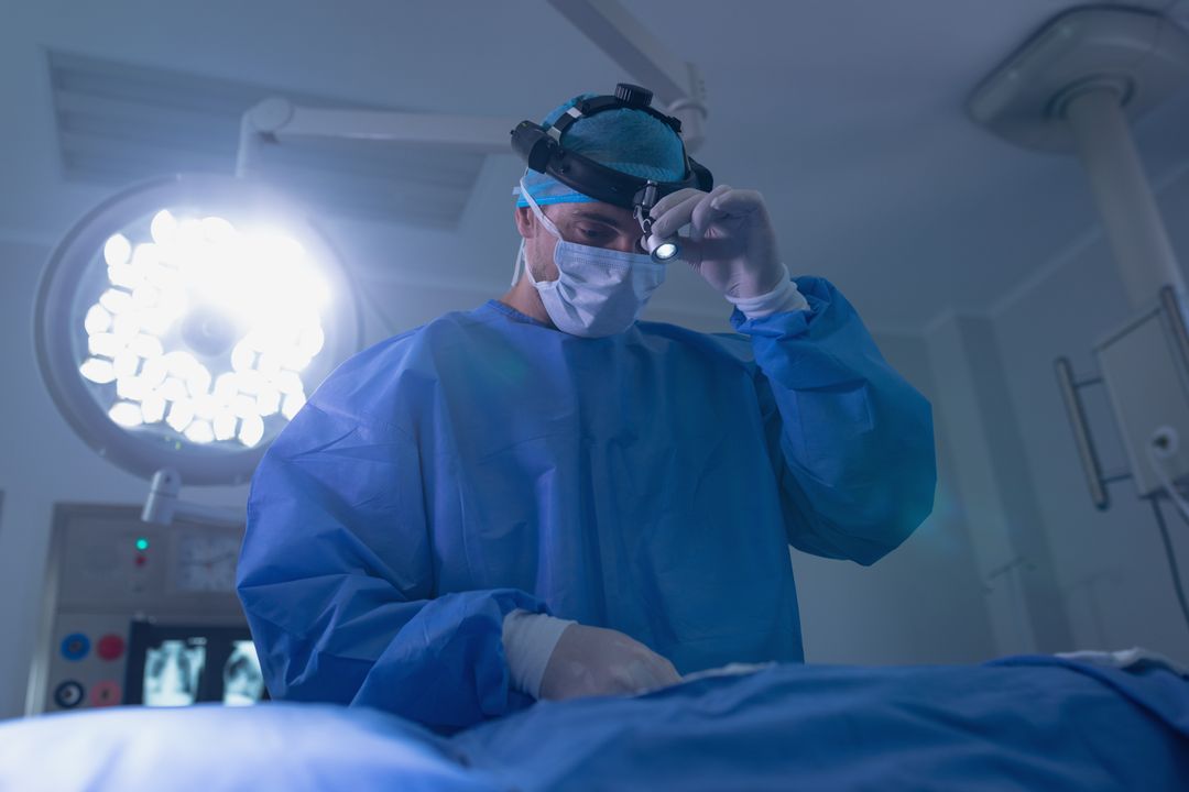 Male surgeon holding surgical headlamp in operating room - Free Images, Stock Photos and Pictures on Pikwizard.com