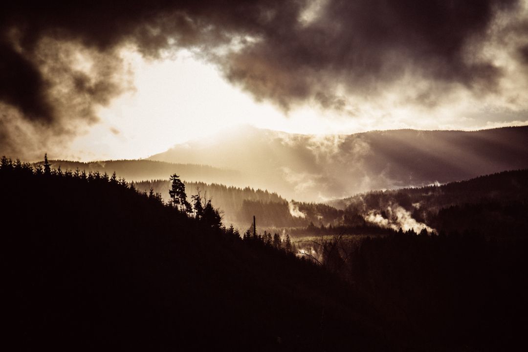 Dramatic Sunrays Breaking Through Clouds Over Misty Mountain Forests - Free Images, Stock Photos and Pictures on Pikwizard.com