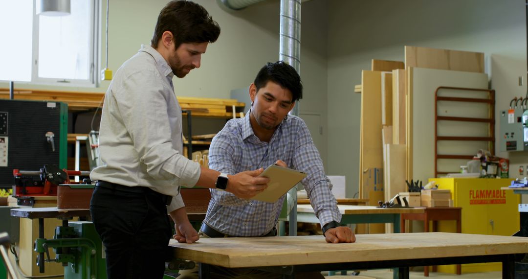 Two Professionals Discussing Plans in Workshop - Free Images, Stock Photos and Pictures on Pikwizard.com