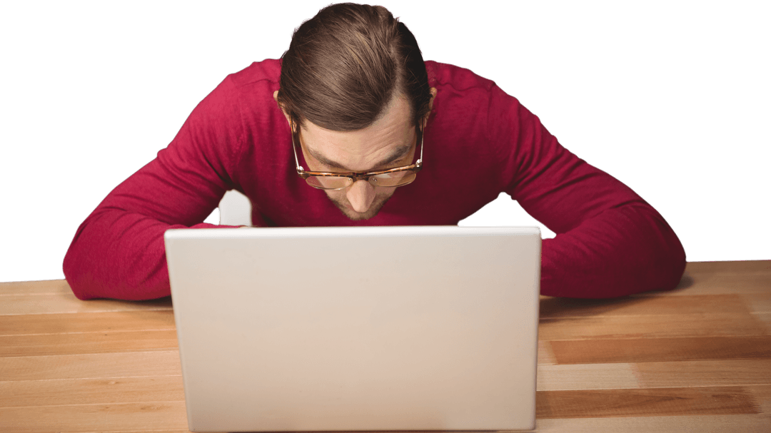 Man in Vibrant Sweater Focusing on Laptop Use at Wooden Desk