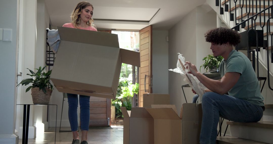 Happy Couple Unpacking and Organizing in New Home