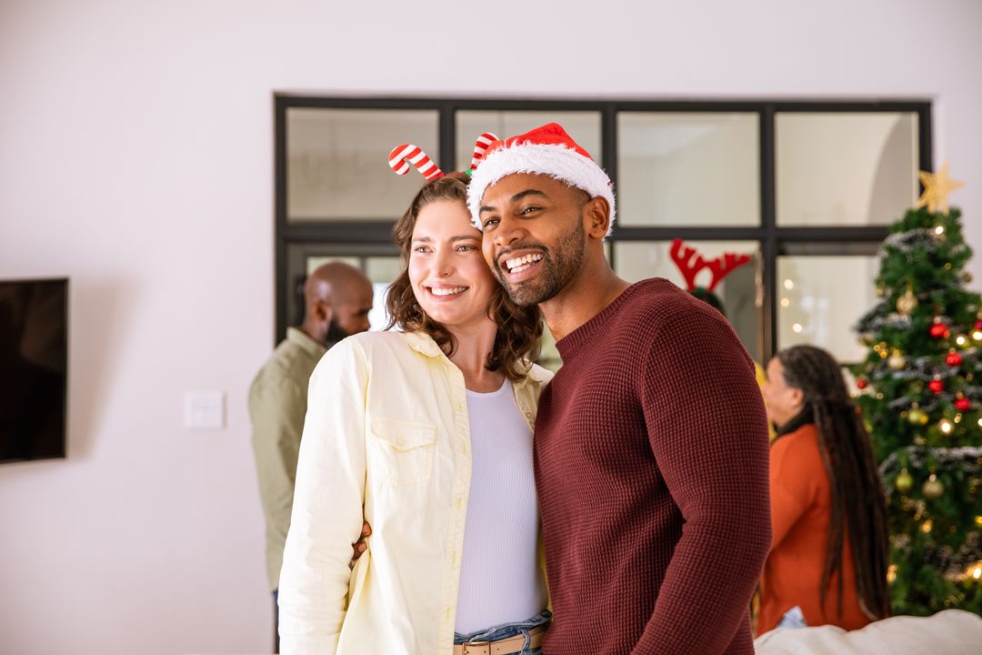 Happy Couple Embracing in Festive Attire by Christmas Tree