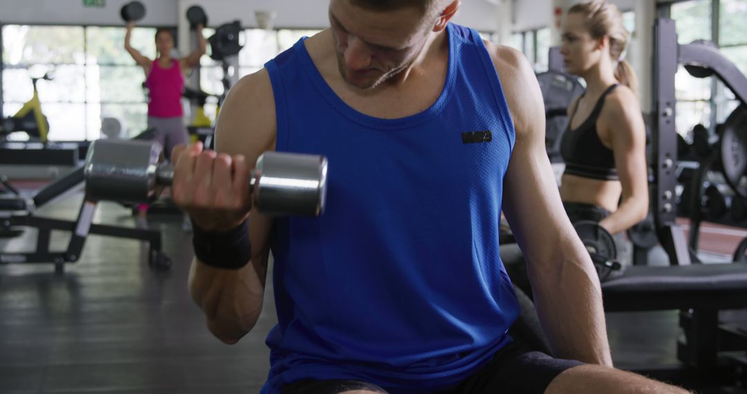 Man Lifting Dumbbell in Gym with Focused Expression - Free Images, Stock Photos and Pictures on Pikwizard.com