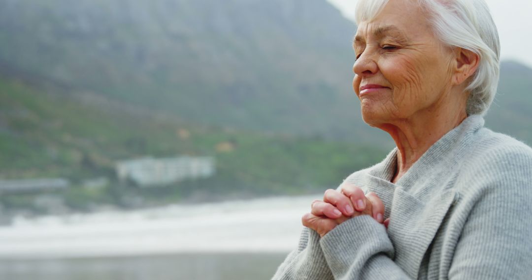 Elderly Woman Meditating Outdoors Near Mountains - Free Images, Stock Photos and Pictures on Pikwizard.com