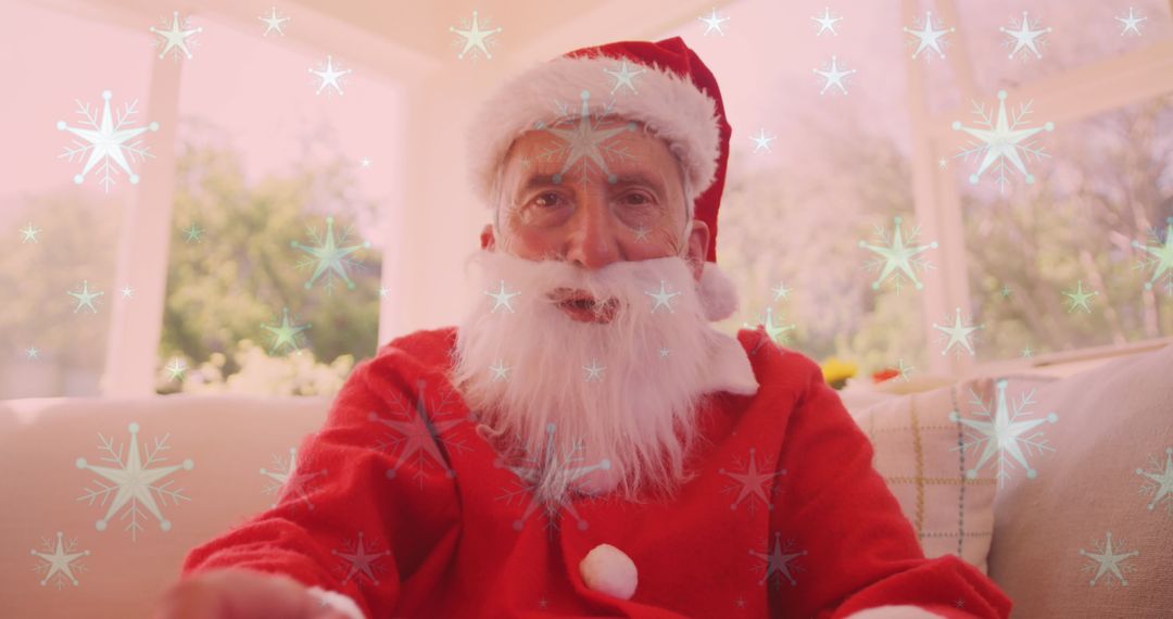 Festive Senior Man in Santa Costume Enjoying Video Call at Home