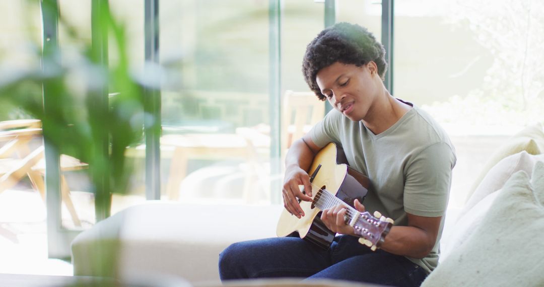 African American Man Playing Guitar at Home in Relaxed Atmosphere