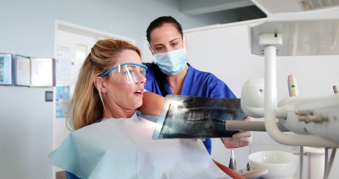 Female Dentist Showing X-ray Results to Patient in Clinic - Free Images, Stock Photos and Pictures on Pikwizard.com