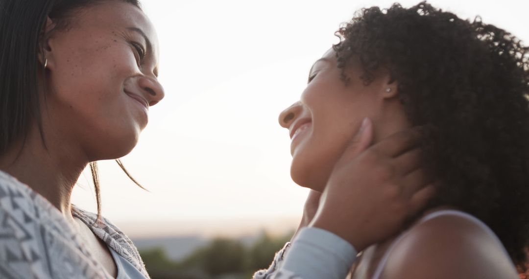 Romantic biracial lesbian couple smiling and embracing in garden at sundown, slow motion - Free Images, Stock Photos and Pictures on Pikwizard.com