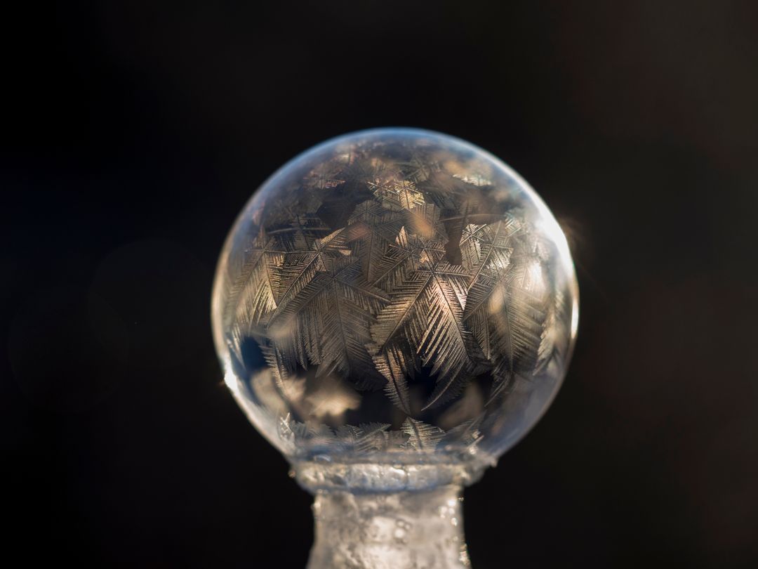 Close-up of frozen soap crystal ball bubble with intricate frost patterns