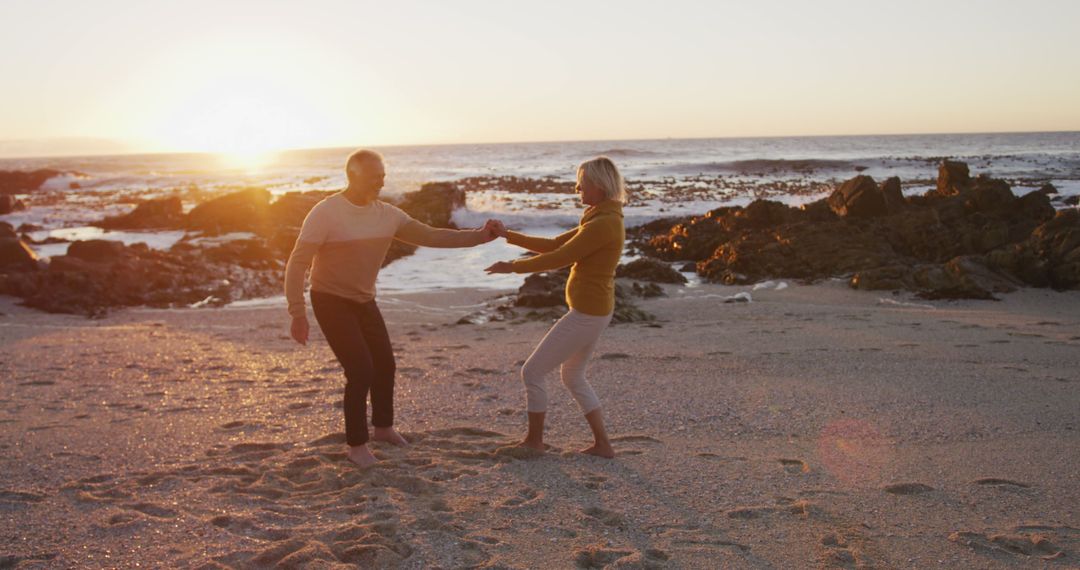 Older couple dancing on serene beach at sunset - Free Images, Stock Photos and Pictures on Pikwizard.com