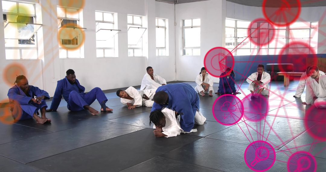 Brazilian Jiu-Jitsu class grappling practice on black mats with blue and white gis