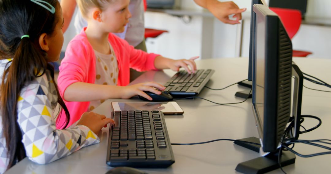 Teacher Assisting Students on Computers in Classroom