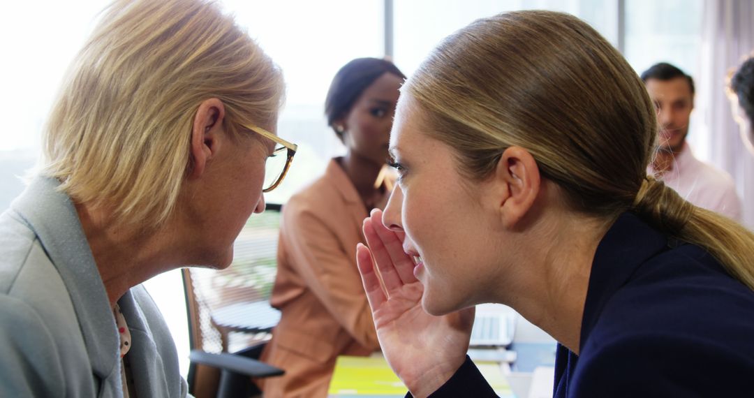 Businesswomen Whispering in Office During Meeting - Free Images, Stock Photos and Pictures on Pikwizard.com