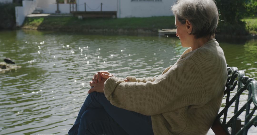 Senior Woman Relaxing by Peaceful Pond - Free Images, Stock Photos and Pictures on Pikwizard.com