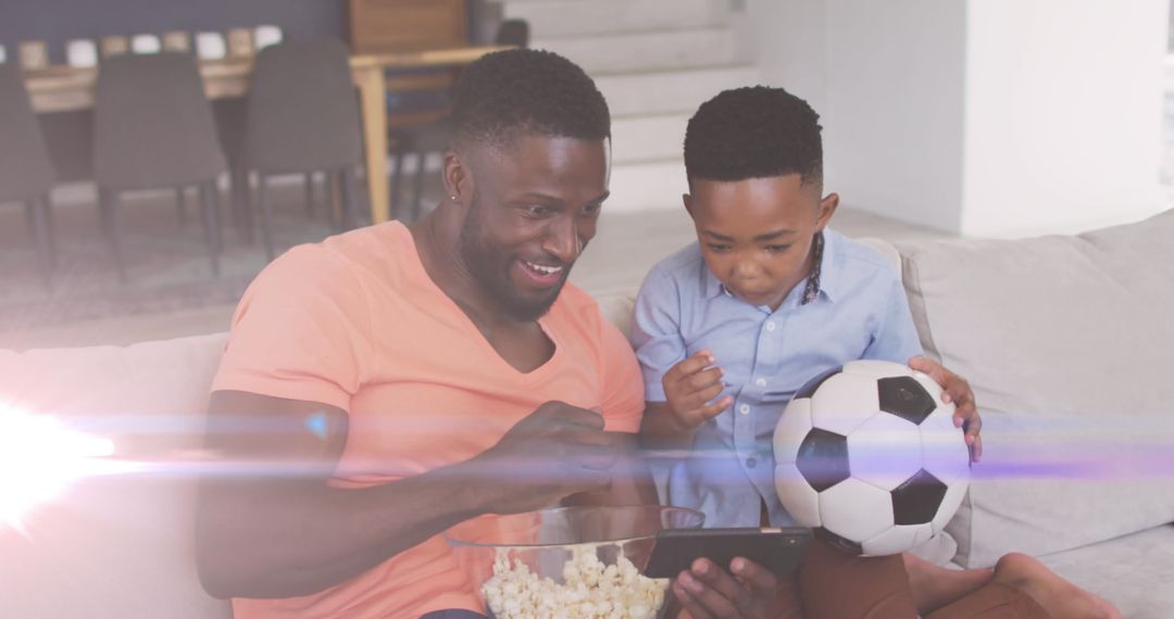 Father and Son Enjoying Soccer Match on Smartphone