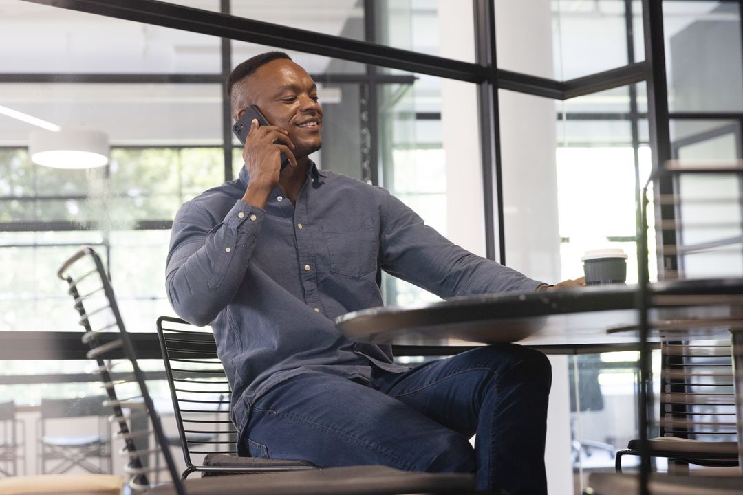 African American Man Talking on Phone in Modern Office Workspace