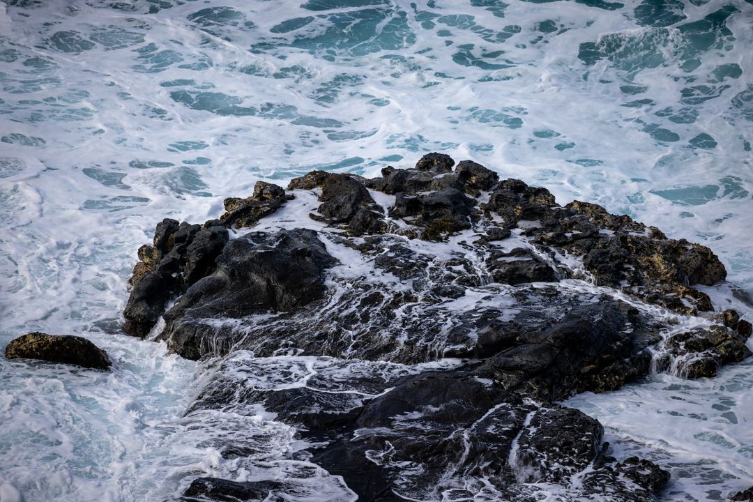 Rough Ocean Waves Crashing Over Black Rocky Shore, Turquoise Foam and Surf Motion