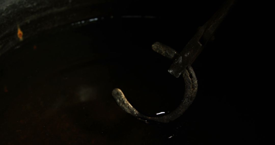 Blacksmith Immersing Hot Horseshoe in Water for Tempering