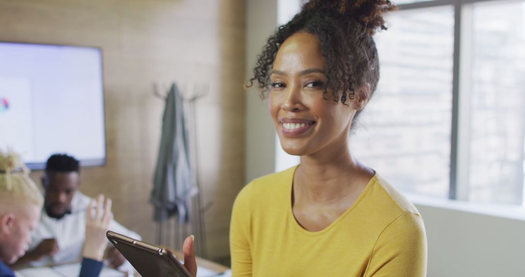 Smiling African American Woman Holding Tablet in Office - Free Images, Stock Photos and Pictures on Pikwizard.com