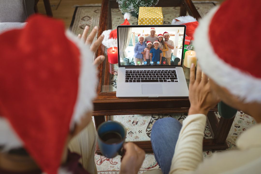 Diverse couple with santa hats having video call with happy caucasian family - Free Images, Stock Photos and Pictures on Pikwizard.com