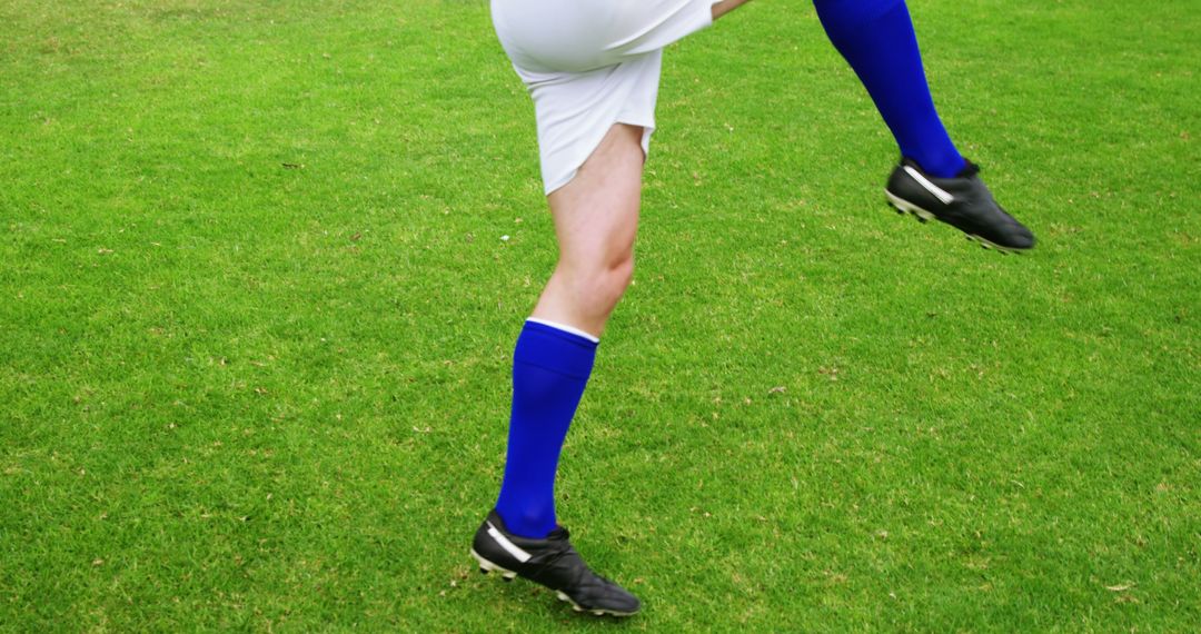 Soccer Player Performing Dynamic Kick on Green Field