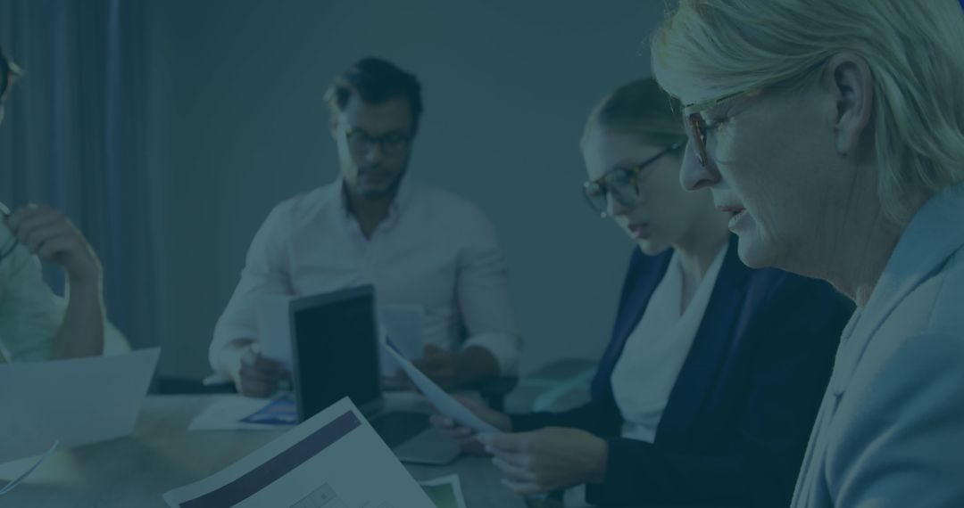 Diverse Team Analyzing Documents in Corporate Office Meeting