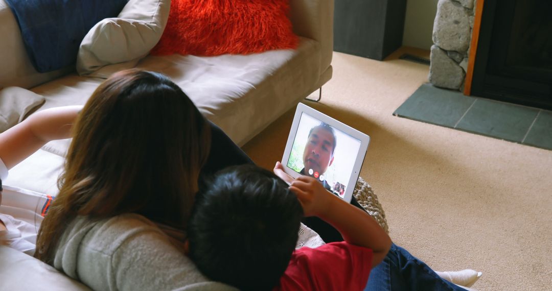 Mother and Child Video Chatting on Tablet in Living Room - Free Images, Stock Photos and Pictures on Pikwizard.com