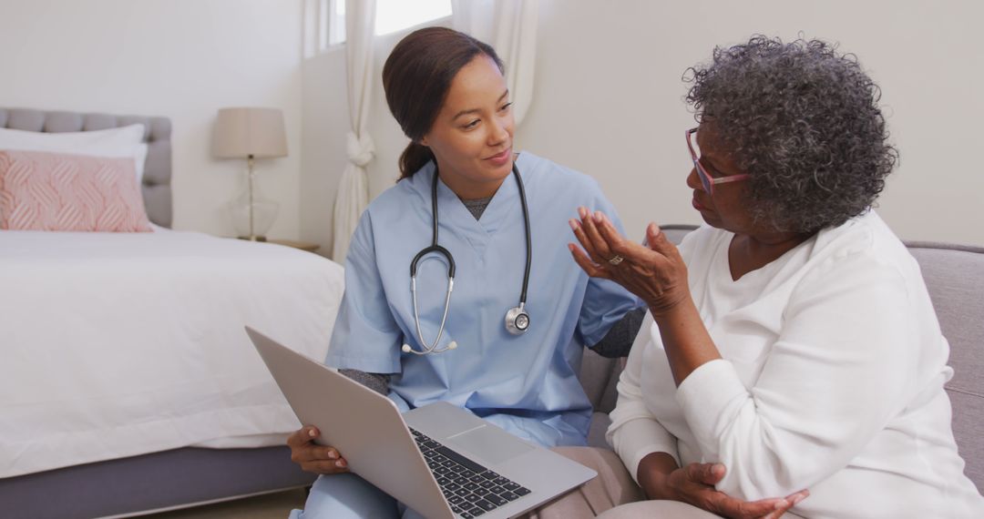 Senior african american woman and female doctor sitting on sofa, using laptop and talking - Free Images, Stock Photos and Pictures on Pikwizard.com