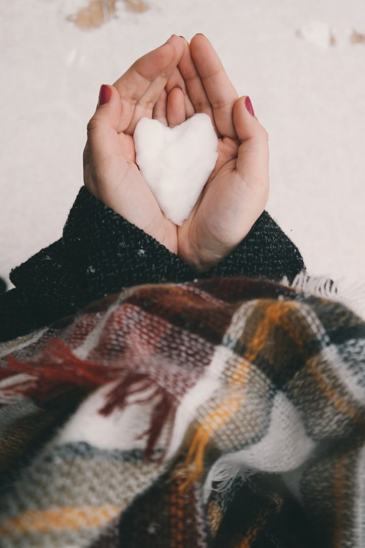 Hands Holding Heart-shaped Snow in Winter