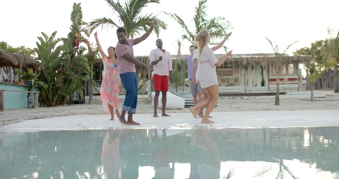 Group of Friends Dancing Joyfully by Tropical Poolside - Free Images, Stock Photos and Pictures on Pikwizard.com