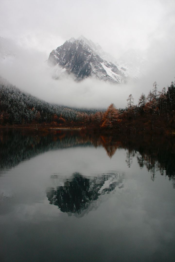 Serene Mountain Reflected in Calm Lake on Misty Autumn Day - Free Images, Stock Photos and Pictures on Pikwizard.com