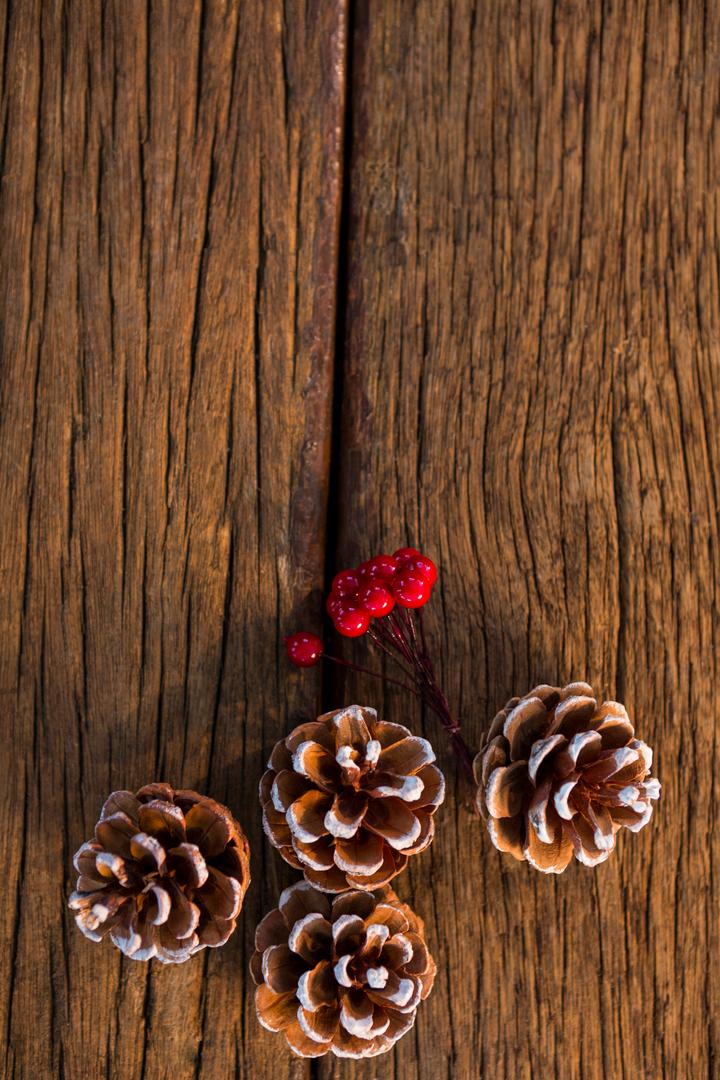 Pine Cones with Snow and Red Berries on Wooden Background - Free Images, Stock Photos and Pictures on Pikwizard.com