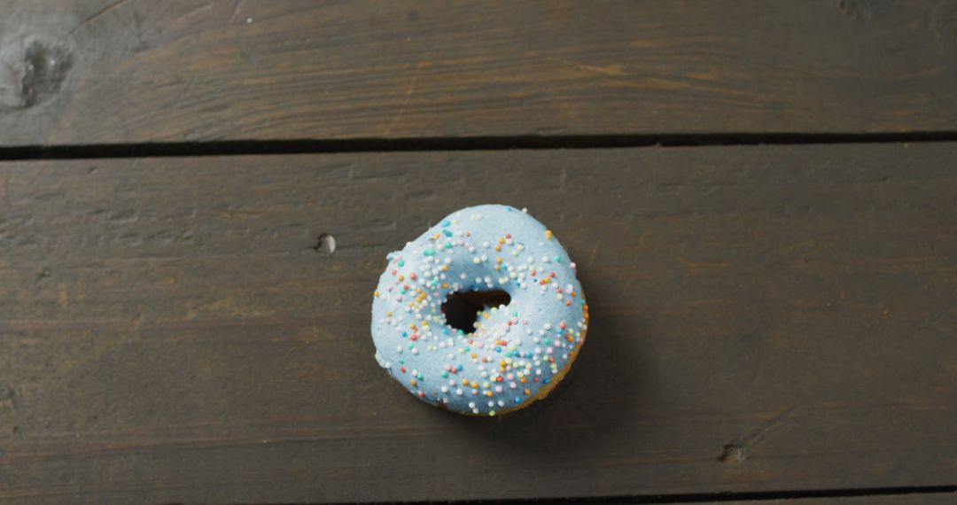 Single Blue Iced Donut with Sprinkles on Wood Surface - Free Images, Stock Photos and Pictures on Pikwizard.com