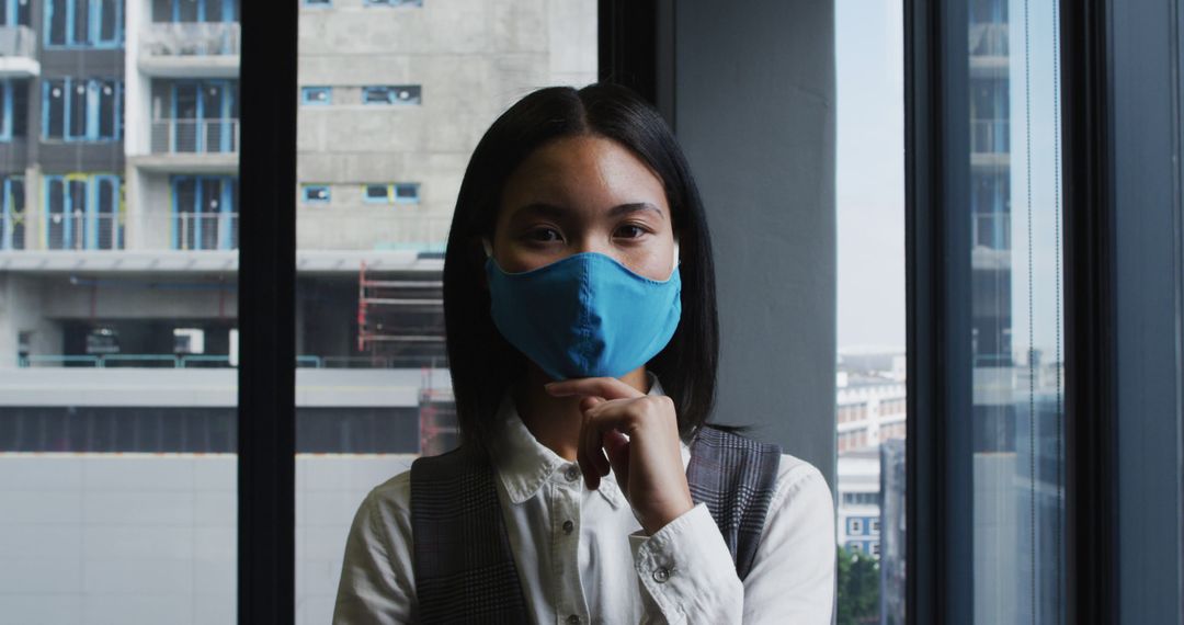 Asian Businesswoman in Face Mask During Pandemic in Modern Office - Free Images, Stock Photos and Pictures on Pikwizard.com