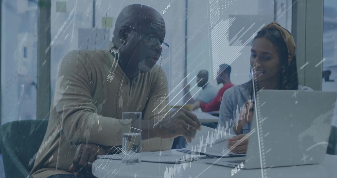 Senior Mentor Guiding Young Professional at Modern Office Workspace