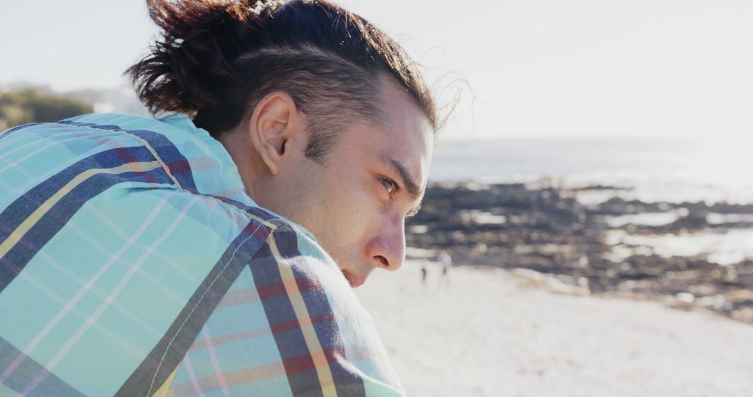 Man with long hair contemplating by seaside - Free Images, Stock Photos and Pictures on Pikwizard.com