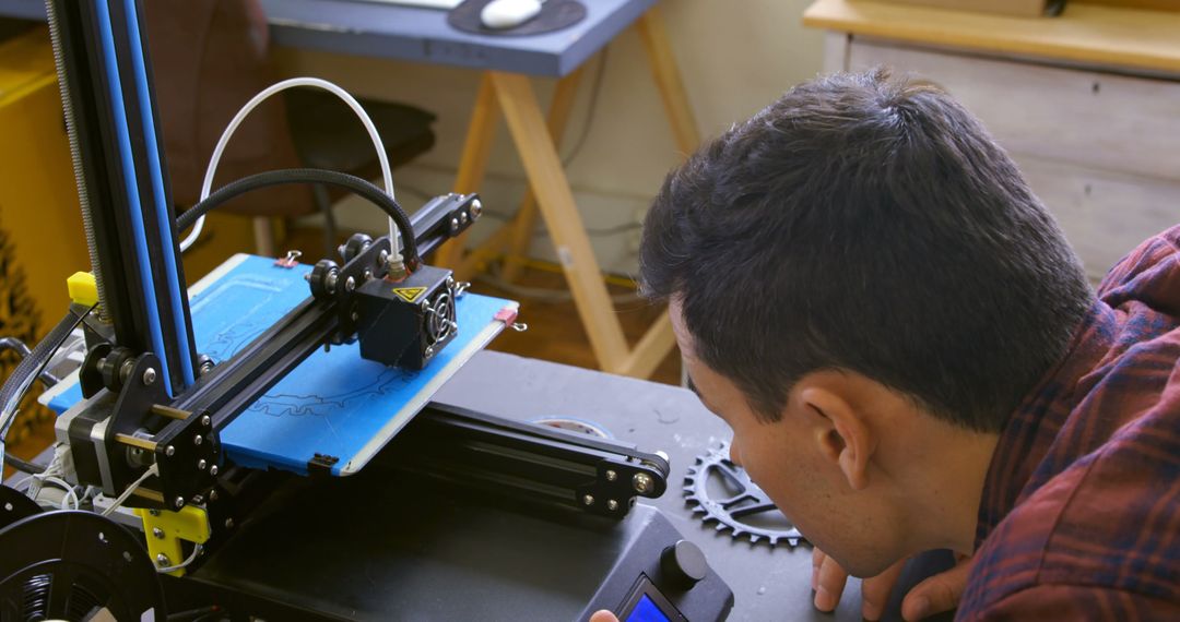 Man Monitoring 3D Printer in Home Office - Free Images, Stock Photos and Pictures on Pikwizard.com