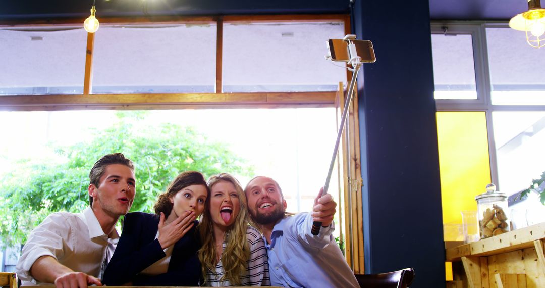 Friends Taking Selfie with Selfie Stick at Café - Free Images, Stock Photos and Pictures on Pikwizard.com