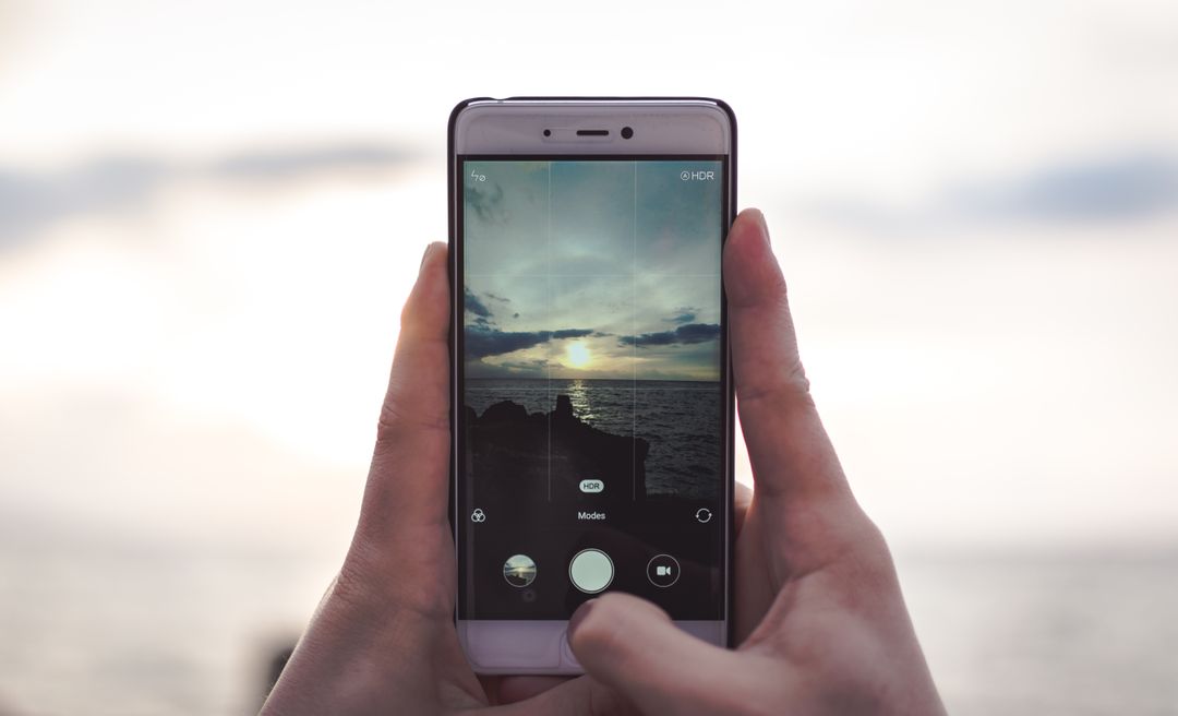 Person capturing scenic sunset with smartphone on the beach - Free Images, Stock Photos and Pictures on Pikwizard.com