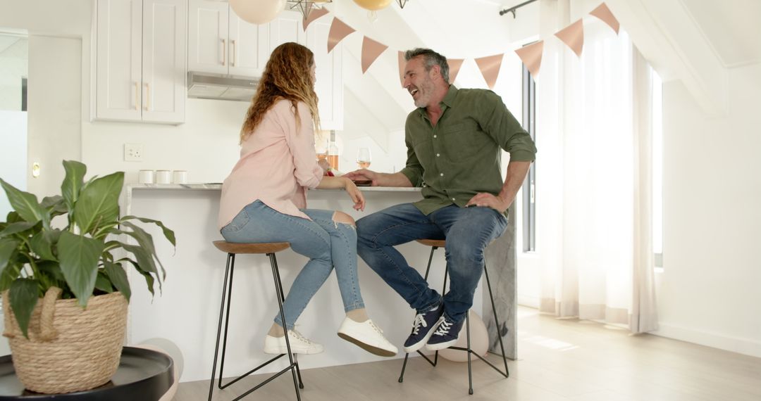 Smiling Couple Relaxing at Kitchen Counter Taking Selfie