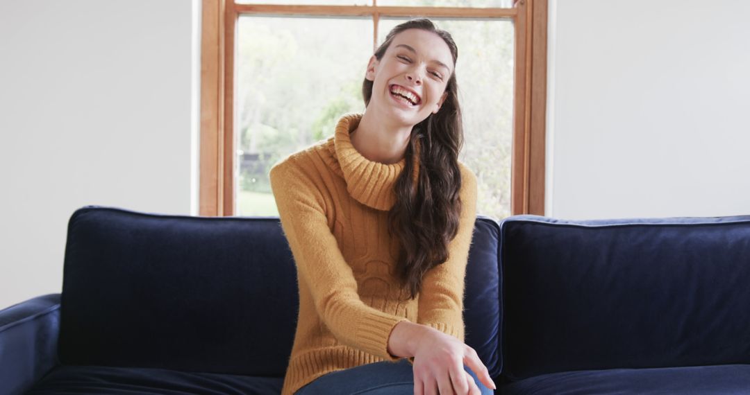 Smiling Woman Sitting on Couch Inside Cozy Living Room - Free Images, Stock Photos and Pictures on Pikwizard.com