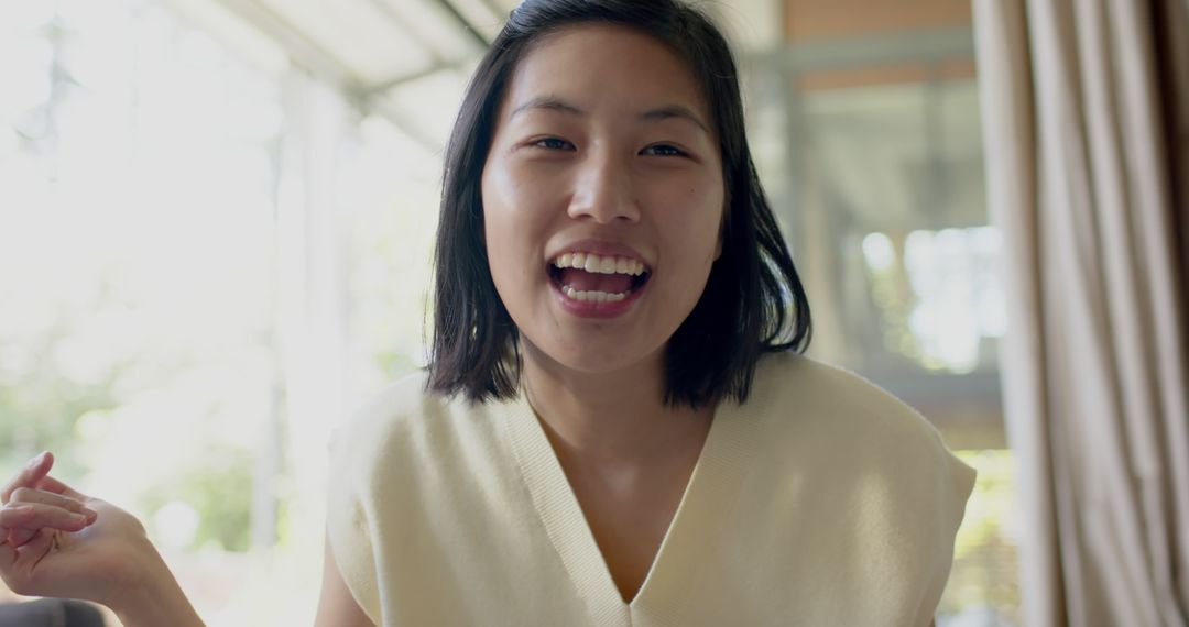 Smiling Asian Woman Engaging in Virtual Communication