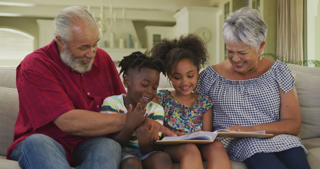 Grandparents Reading Storybook with Happy Grandchildren on Sofa - Free Images, Stock Photos and Pictures on Pikwizard.com