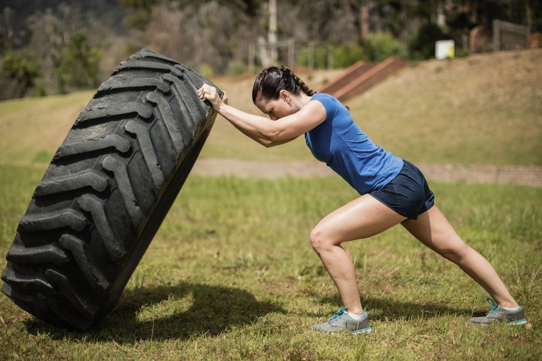 Female Athlete Tire Flipping in Outdoor Fitness Training