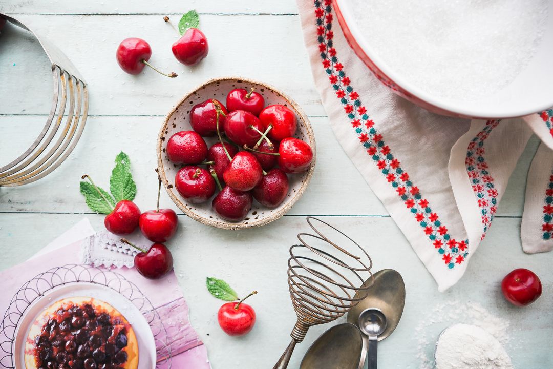 Fresh cherry background and baking ingredients on rustic table